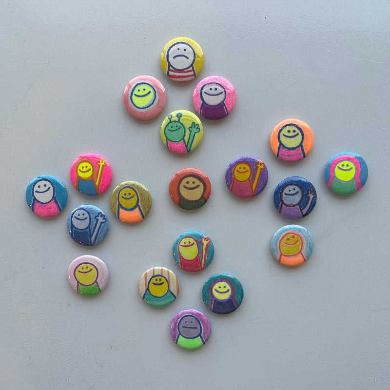 Colorful magnets with smiley face designs arranged on a white surface