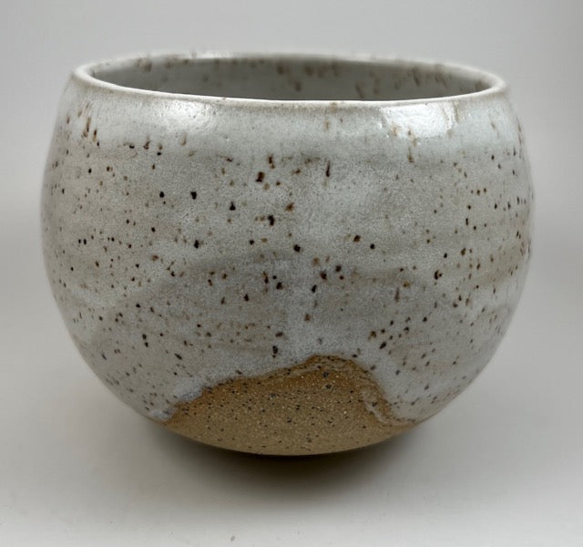 Speckled ceramic bowl on a plain background