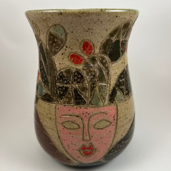 Ceramic vase with artistic face design on a white background