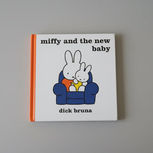 Book titled 'miffy and the new baby' by Dick Bruna on a gray background