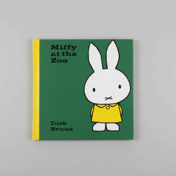 Book cover of 'Miffy at the Zoo' by Dick Bruna on a wooden surface