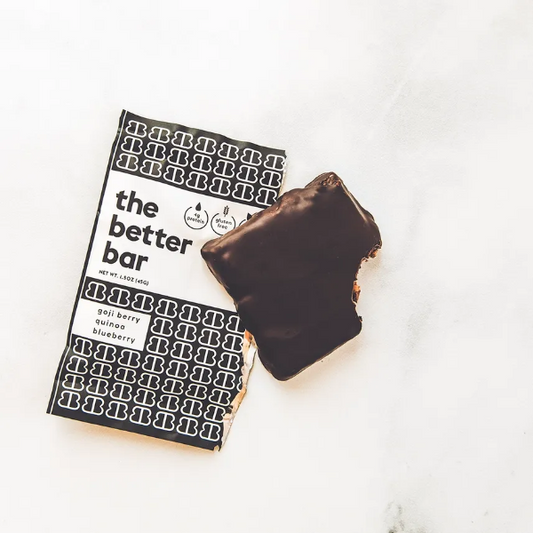 Chocolate-covered bar next to a 'the better bar' packaging on a white surface