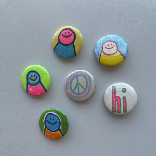 Set of colorful pins with various designs on a gray background