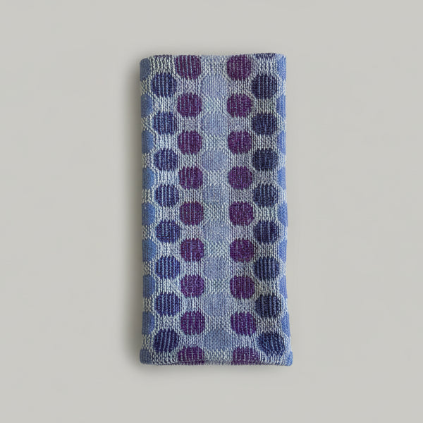 Blue and purple polka dot fabric on a marble surface